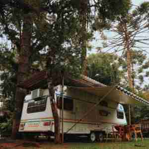 RV parked under tall trees. A Girard tankless water heater will provide long hot showers wherever the water supply is available.