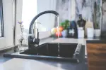 Water flowing from a tap equipped with plumbing materials for healthier living spaces
