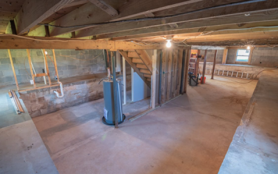 A water heater in an empty basement. Placing the water heater in line with the stairwell can be an excellent position to hide your water heater during renovations.