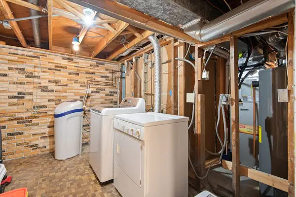 White top load washing machine and dryer in a laundry area