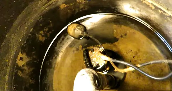 Water level in a sump basin with pump and discharge pipe.